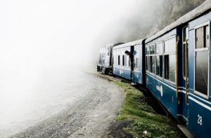 toy train travelling beside a hill through clouds