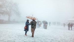 people standing under the snowfall